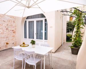 a white table and chairs under a white umbrella at Villa Aurelia Suites and Apartments in Locorotondo