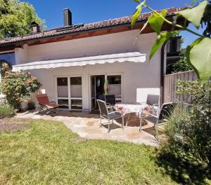 a patio with a table and chairs in front of a house at Im Inntal Dahoam in Brannenburg