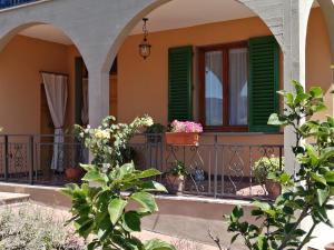 ein Haus mit grünen Rollläden und Topfpflanzen auf einem Balkon in der Unterkunft San Bartolo Rent Apartments, due passi da Firenze in Fiesole