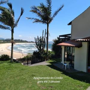 a house with a view of a beach with palm trees at De frente para o Mar da Gamboa in Garopaba