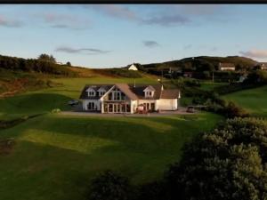 an aerial view of a house on a golf course at Woodland Lodge in Port na Long