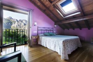 a bedroom with a bed and a large window at La Posada de Cucayo in Dobres