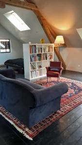 Le Loft في Sancergues: غرفة معيشة مع أريكة وكرسي