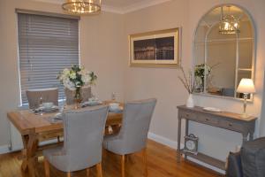 een eetkamer met een houten tafel en stoelen bij Sea Haven in Conwy