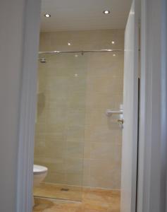 a bathroom with a glass shower with a toilet at Sea Haven in Conwy