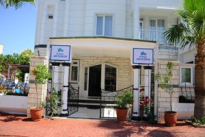 a white building with plants in front of it at Amsterdam Otel & Suite Apart in Kemer