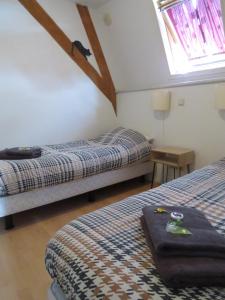 a bedroom with two beds and a table and a window at B&B Sagenland in Harbrinkhoek