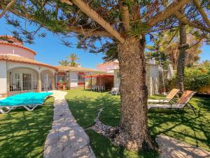 a yard with a tree and a house at Beachfront Villa Torrox Costa in Torrox Costa