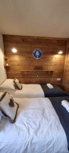 ein Schlafzimmer mit 2 Betten und einer Uhr an der Wand in der Unterkunft Luxury Central Apartment MONTCHAVIN in Bellentre