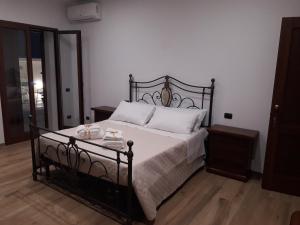 - une chambre avec un lit noir et des oreillers blancs dans l'établissement Angelica, à Lecce