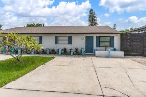 a white house with a blue door at Cortez Gardens Cottage 15, Renovated and close to Beach, 3-Bed, 2-Bath 10 People in Bradenton