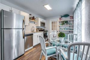 a kitchen with a stainless steel refrigerator and a table with chairs at Cortez Gardens Cottage 15, Renovated and close to Beach, 3-Bed, 2-Bath 10 People in Bradenton