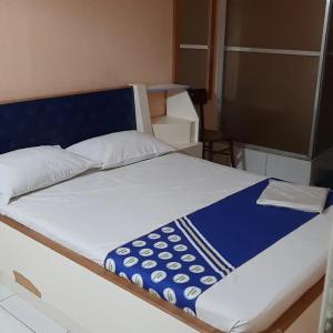 a bed with a blue and white blanket on it at OYO Hotel Macedo in Sao Paulo