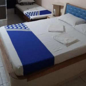 OYO Hotel Macedo في ساو باولو: سريرين في غرفة باللون الأزرق والأبيض