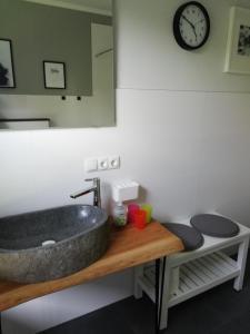 a bathroom with a sink and a clock on the wall at Ferienwohnung am Welper-Wald-Vechta-Süd in Vechta