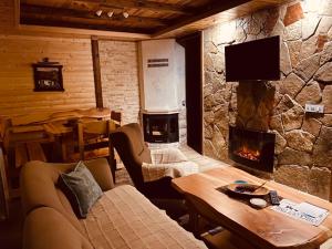 sala de estar con chimenea, sofá y mesa en Holiday Homes Durmitorski Gaj en Žabljak