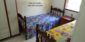 a bedroom with two twin beds and a window at De frente para o Mar da Gamboa in Garopaba