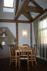 uma sala de jantar com uma mesa de madeira e cadeiras em Goldingen em Kuldīga