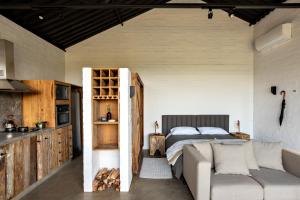 a bedroom with a bed and a couch in a room at Mataka'a - Chalé Industrial na Mantiqueira in Gonçalves