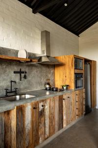 una cocina con armarios de madera y fregadero en Mataka'a - Chalé Industrial na Mantiqueira en Gonçalves