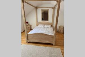 Bernissart的住宿－Au petit ravel Loft cosy au coeur de la nature，一间卧室配有天蓬床和镜子