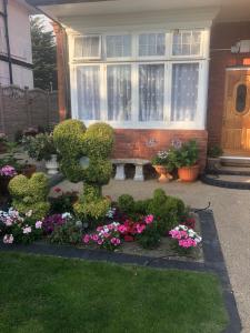 a house with a garden with flowers and a bench at ElMurrs in Bournemouth