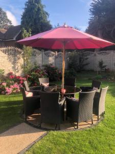 a table and chairs under an umbrella in a yard at ElMurrs in Bournemouth