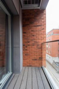 an empty balcony of a building with a brick wall at Modern Flat 5 mins to Northern Q in Manchester