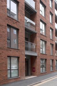ceglany budynek z balkonami na boku w obiekcie Modern Flat 5 mins to Northern Q w Manchesterze