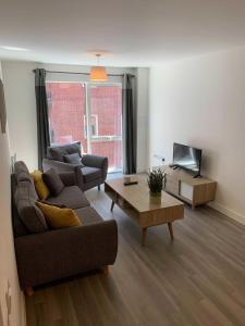 a living room with a couch and a coffee table at Modern Flat 5 mins to Northern Q in Manchester