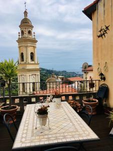 a table and chairs on a balcony with a clock tower at U Campanin in Vallebona