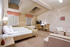 sypialnia z łóżkiem, kanapą i biurkiem w obiekcie Hotel Stara Kamienica w mieście Piekary Śląskie