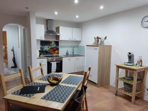 a kitchen with a wooden table and a dining room at Ferienwohnung An der Kapelle in Rickenbach