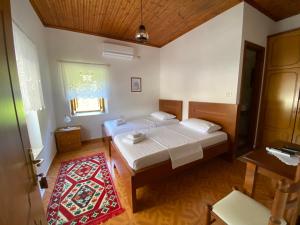 a bedroom with two beds and a window and a rug at Old Town Hotel in Gjirokastër