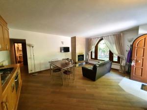 a kitchen and living room with a table and a couch at Albergo Villino Quintiliani in Pescasseroli