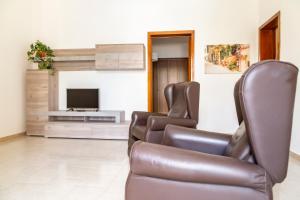 un soggiorno con 2 sedie e una TV di La Curte dellu Pippi Niuru a Lecce