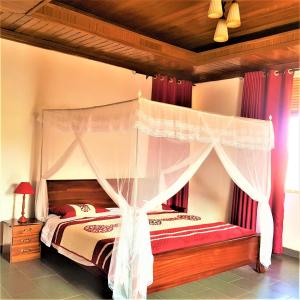 sypialnia z łóżkiem z baldachimem w obiekcie Maison de Passage - Isaro Passage House - Vacation Rental In Kigali w mieście Kigali