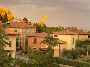 a group of buildings with a clock tower in the background at La terrazza da Barbara in Torrita di Siena