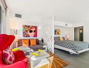 a bedroom with a bed and a red chair at The Twist Palm Springs in Palm Springs