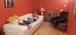ein Wohnzimmer mit einer weißen Couch mit Kissen in der Unterkunft La cigale et la fourmi in Nîmes