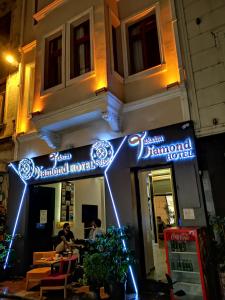 taksim diamond hotel في إسطنبول: مطعم به لافتات نيون على جانب المبنى