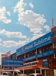 a building with signs on the side of it at Hotel Sublime - Pistão Sul - Próximo a Universidade Católica de Brasília in Taguatinga