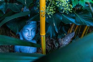 una statua blu seduta accanto a delle piante verdi di Little India Vijlen appartement 1 a Vijlen