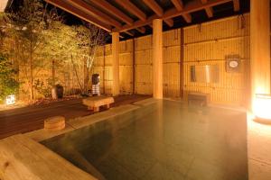 um pavilhão com piscina no meio de uma sala em Hotel Yumeshizuku em Minami Aso