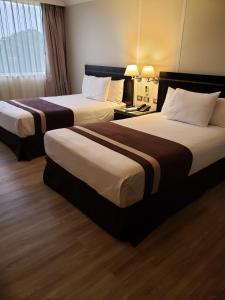 a hotel room with two beds in a room at Hotel Diego de Almagro La Serena in La Serena
