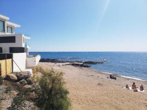 een groep mensen op een strand bij de oceaan bij Appartement Studio cap d'agde avec vue port et piscine in Cap d'Agde