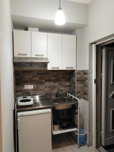 a kitchen with white cabinets and a sink at Miltos rooms in Leptokaria