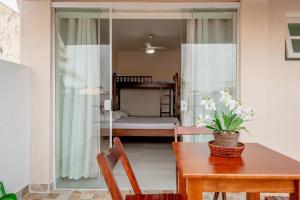 une salle à manger avec une table et une chambre dans l'établissement Pousada Oásis, à Peruíbe