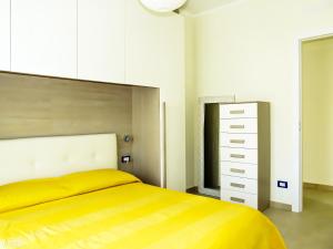 ein Schlafzimmer mit einem gelben Bett und einer Kommode in der Unterkunft Pietra Home, posto auto, AC ,WIFI, 150mt dal mare in Pietra Ligure