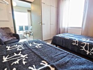 a hotel room with two beds and a chair at Levin keskusta, Tunturinlaita B9 in Levi